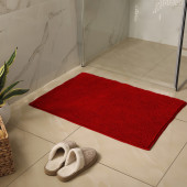 tapis de bain rouge posé sur carrelage salle de bains