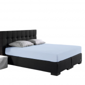 Visuel d'ambiance, le drap housse en jersey extensible bleu mis sur tout le lit sur fond blanc