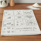 torchon de cuisine montagne gris, dessins savoyard gris sur fond beige, 100% coton 50x70cm sur fond d'ambiance, table en bois.