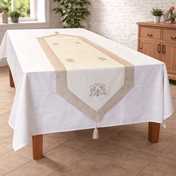 Chemin de table installé sur la table, légerement tombant. Chemin de table couleur lin et blanc, broder